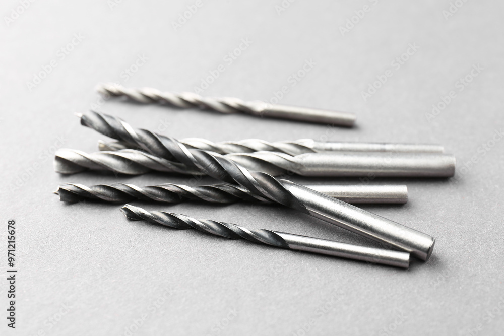 Many different drill bits on light grey table Many different drill bits on light grey table