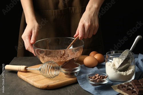 Woman making chocolate dough at grey table, closeup