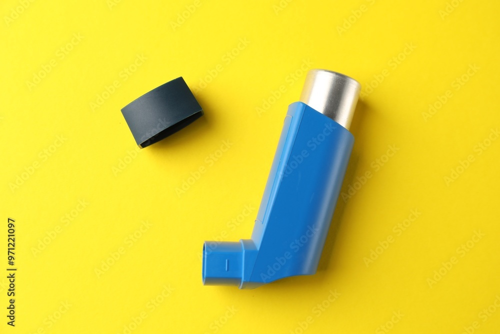Asthma inhaler on yellow background, top view Asthma inhaler on yellow background, top view