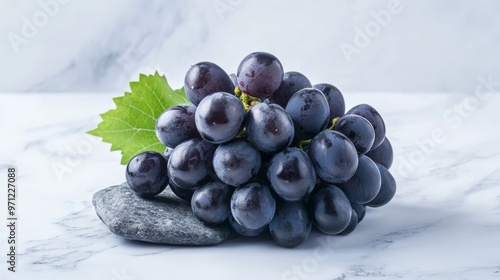 Lots of fresh black grapes on stone, white background. photo