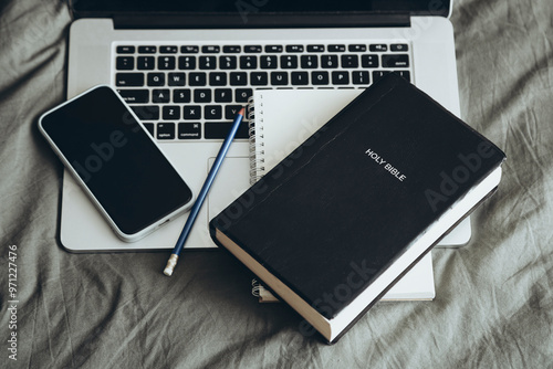 Bible, phone, laptop and cup of coffee on a grey bed background. studying Bible.