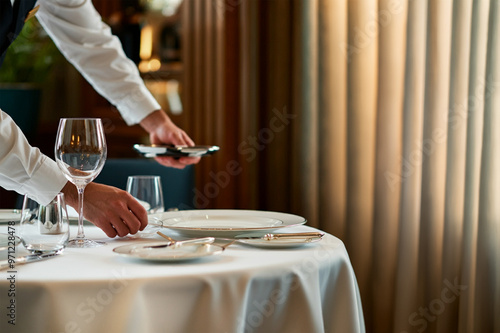 Waiter serving at an empty table. photo