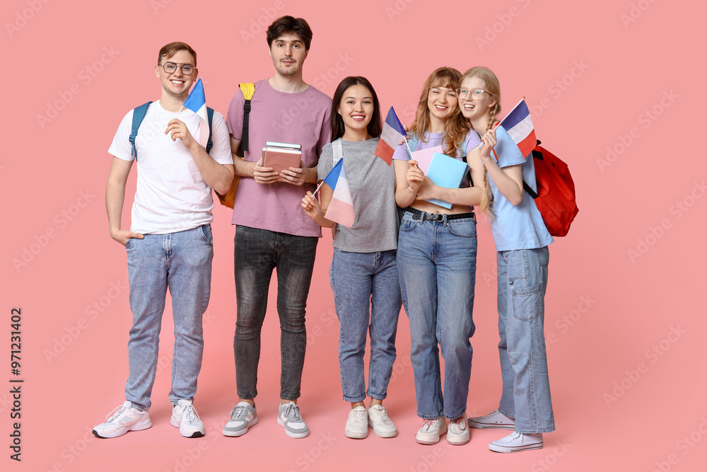 Fototapeta premium Group of students with French flags on pink background
