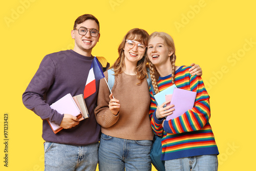 Group of students with French flags on yellow background