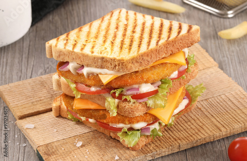 toast fried chicken sandwich, hummer sandwich on wood background with fries