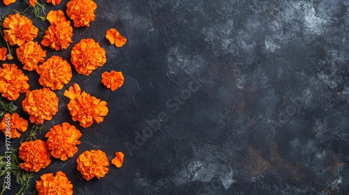 Bright orange marigold flowers arranged on a dark textured surface.