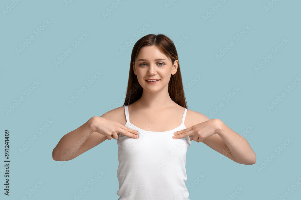 Young woman checking her breast on blue background Young woman checking her breast on blue background