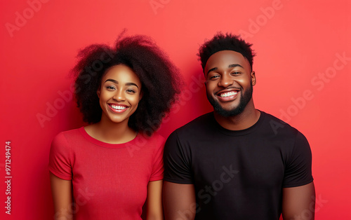 Portrait of cheerful black young couple isolated over red background and empty space for text.