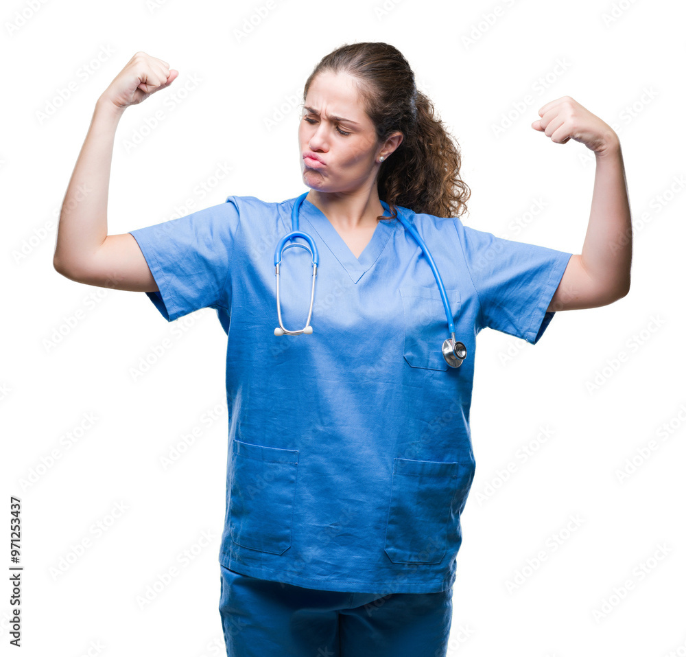 Young brunette doctor girl wearing nurse or surgeon uniform over isolated background showing arms muscles smiling proud. Fitness concept. Young brunette doctor girl wearing nurse or surgeon uniform over isolated background showing arms muscles smiling proud. Fitness concept.