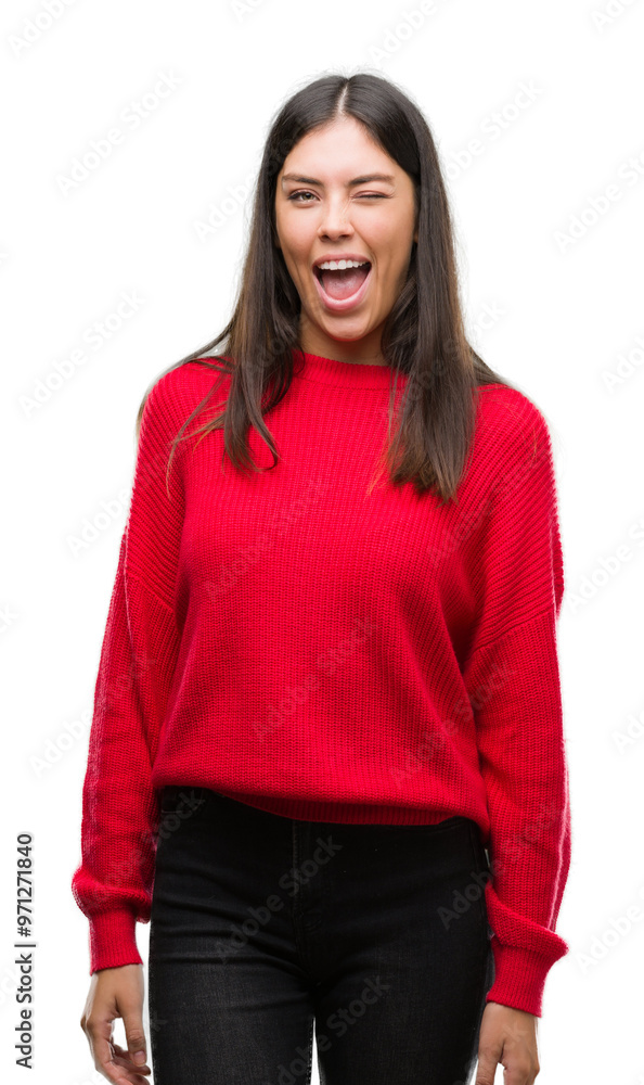 Young beautiful hispanic wearing red sweater winking looking at the camera with sexy expression, cheerful and happy face. Young beautiful hispanic wearing red sweater winking looking at the camera with sexy expression, cheerful and happy face.