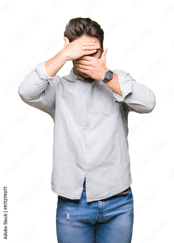 Young handsome man wearing glasses over isolated background Covering eyes and mouth with hands, surprised and shocked. Hiding emotion Young handsome man wearing glasses over isolated background Covering eyes and mouth with hands, surprised and shocked. Hiding emotion