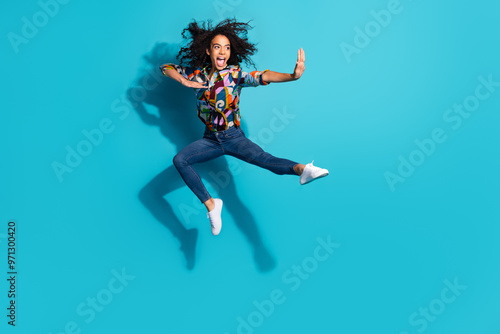 Photo of cheerful crazy girl wear stylish clothes fly air empty space isolated on blue color background