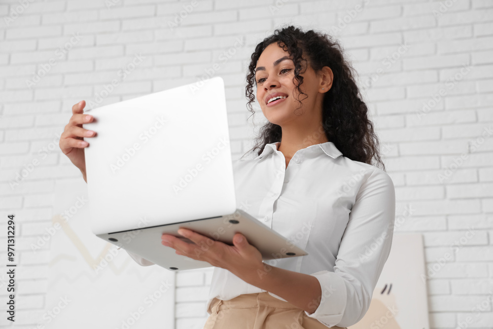 Pretty young African-American woman with laptop at home Pretty young African-American woman with laptop at home