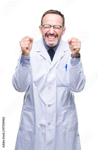 Middle age senior hoary professional man wearing white coat over isolated background excited for success with arms raised celebrating victory smiling. Winner concept.