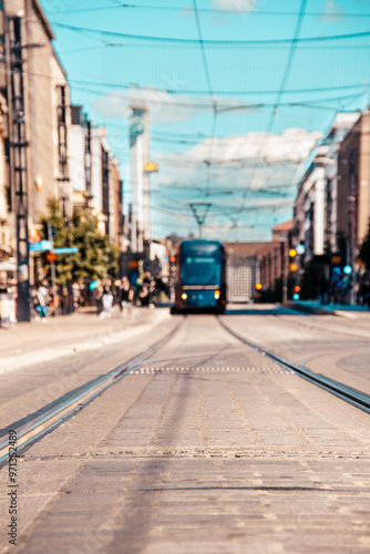Tampere tramway rails in city center with a tram in the background.