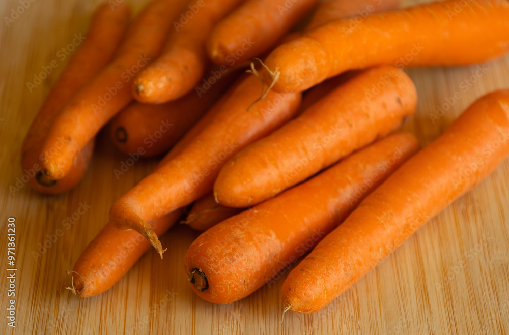 Bunch of Fresh Organic Carrots on a Wooden Chopping Board Close-Up Bunch of Fresh Organic Carrots on a Wooden Chopping Board Close-Up