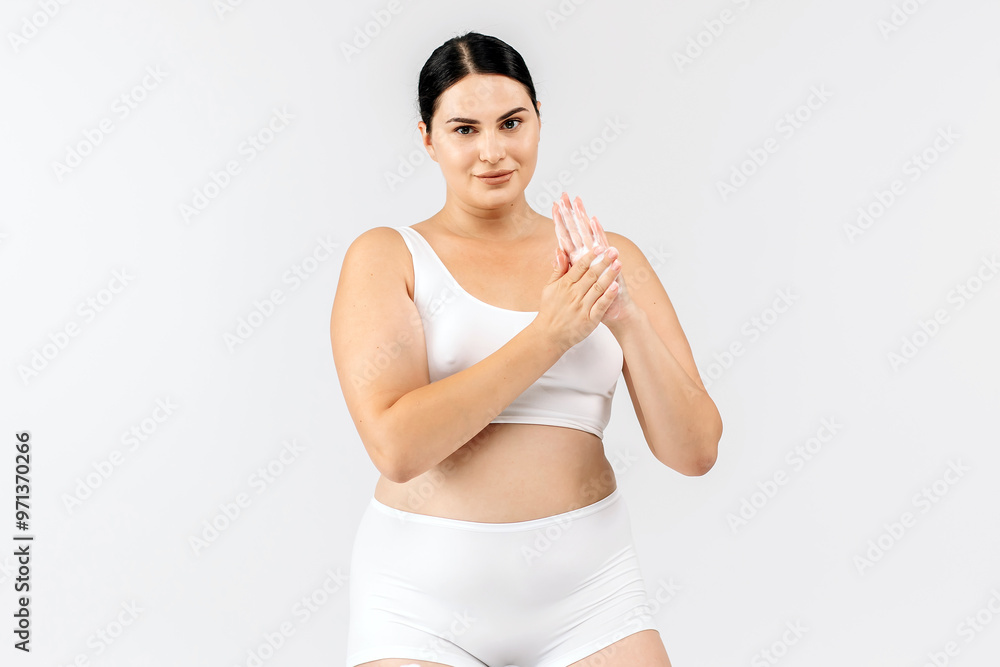 Young, beautiful brunette with curvy figure using skincare products on a white background. Perfect for promoting skincare, emphasizing confidence and beauty with your products. Young, beautiful brunette with curvy figure using skincare products on a white background. Perfect for promoting skincare, emphasizing confidence and beauty with your products.