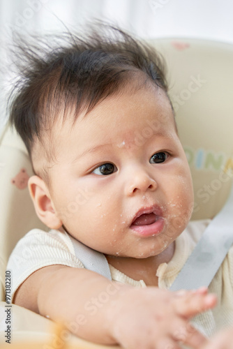 a baby sitting in a high chair with a spoon in it's mouth photo