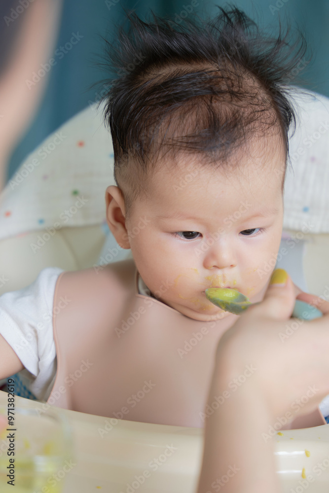 a baby sitting in a high chair eating food a baby sitting in a high chair eating food