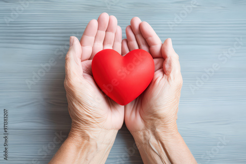 A Red  heart in woman's hand support on aging a wooden table  background for promoting health care campaign concept, Heart day, Hear attact, Valentine's day photo