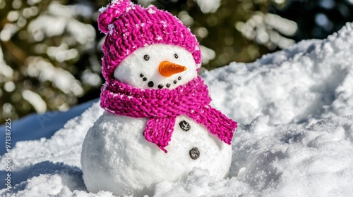 Little cute snowman in a knitted hat and scarf on snow on a sunny winter day. Christmas card photo