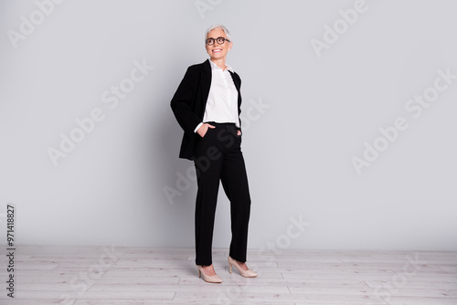 Full length photo of charming gorgeous successful lady wear trendy black suit look empty space isolated on grey color background