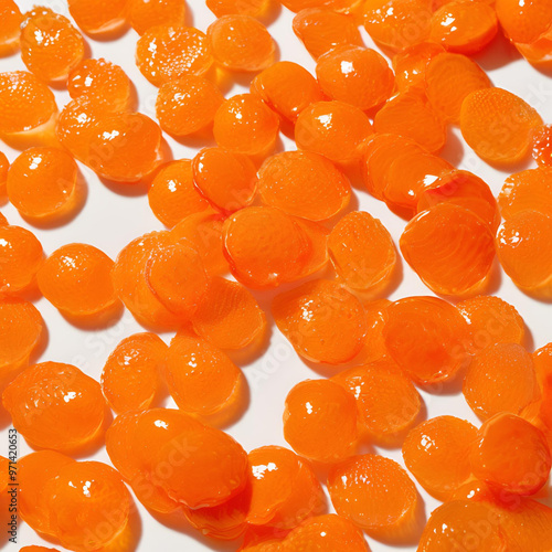 shows a close-up of numerous small, round, orange objects arranged in a pattern. They appear to be translucent or semi-translucent, with a slightly shiny surface.