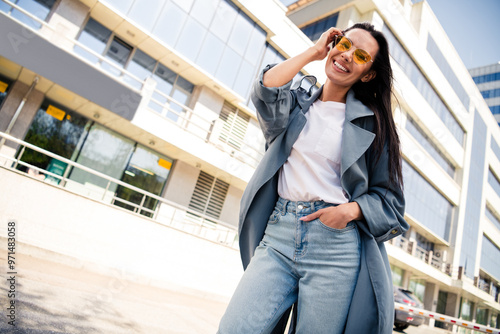 Photo of charming positive woman wear grey trench dark glasses choosing new apartment enjoying walk outdoors urban city street