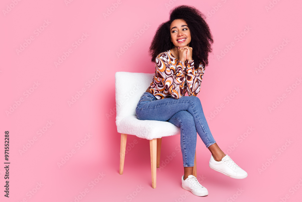 Full length photo of charming girly woman wear print shirt sitting stool looking empty space isolated pink color background Full length photo of charming girly woman wear print shirt sitting stool looking empty space isolated pink color background