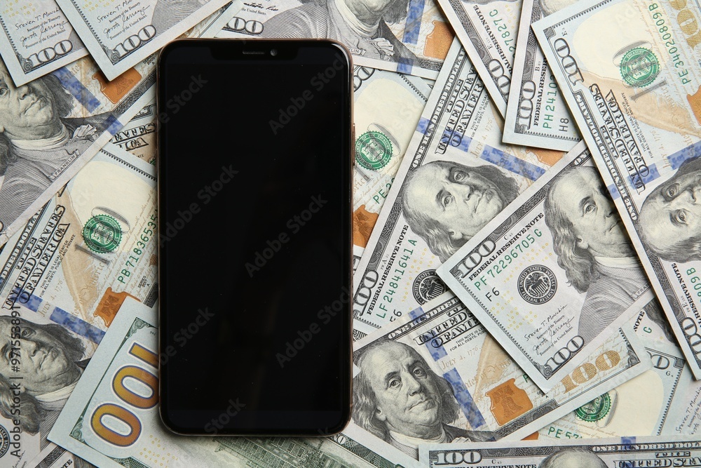 Fototapeta premium Modern smartphone on dollar bills, top view