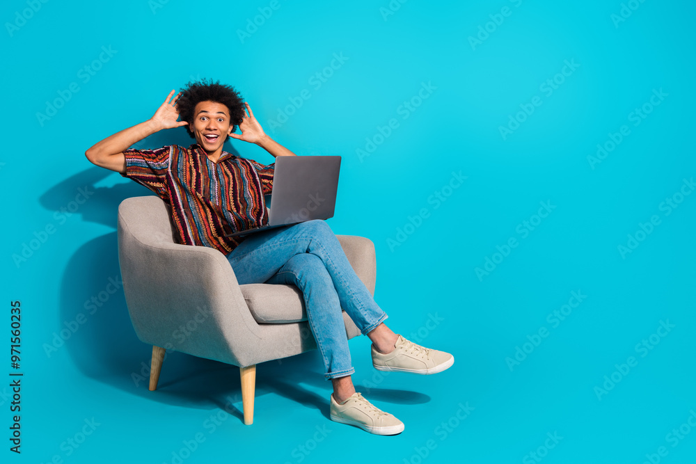 Full size photo of nice young man sit chair laptop empty space wear shirt isolated on teal color background Full size photo of nice young man sit chair laptop empty space wear shirt isolated on teal color background