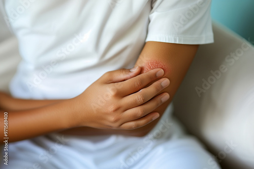 A close-up image showing a person examining a rash on their elbow, highlighting the detail and texture of the irritated skin against a blurred background