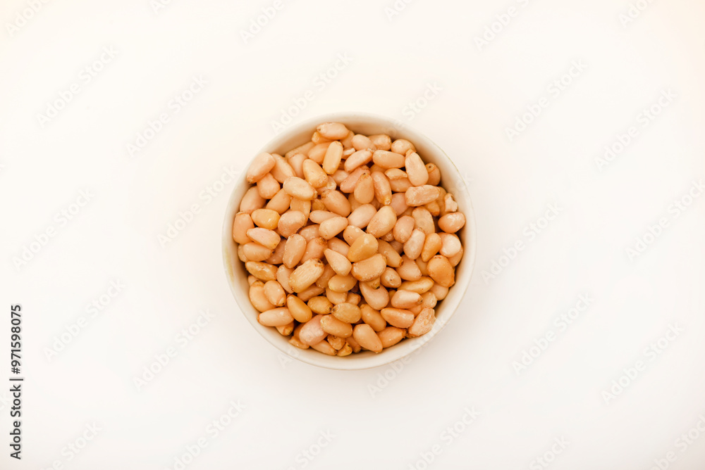 Pine nuts on a white plate. Hazelnuts. Pine nuts on a white plate. Hazelnuts.