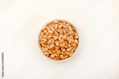 Pine nuts on a white plate. Hazelnuts.