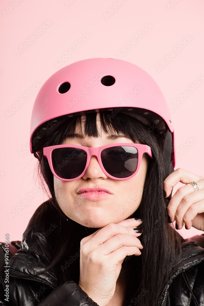 Woman, studio and sunglasses with bicycle helmet for transportation and riding on pink background. Female person, fashion and edgy or confident with wearing safety gear for bike or cycling in style Woman, studio and sunglasses with bicycle helmet for transportation and riding on pink background. Female person, fashion and edgy or confident with wearing safety gear for bike or cycling in style