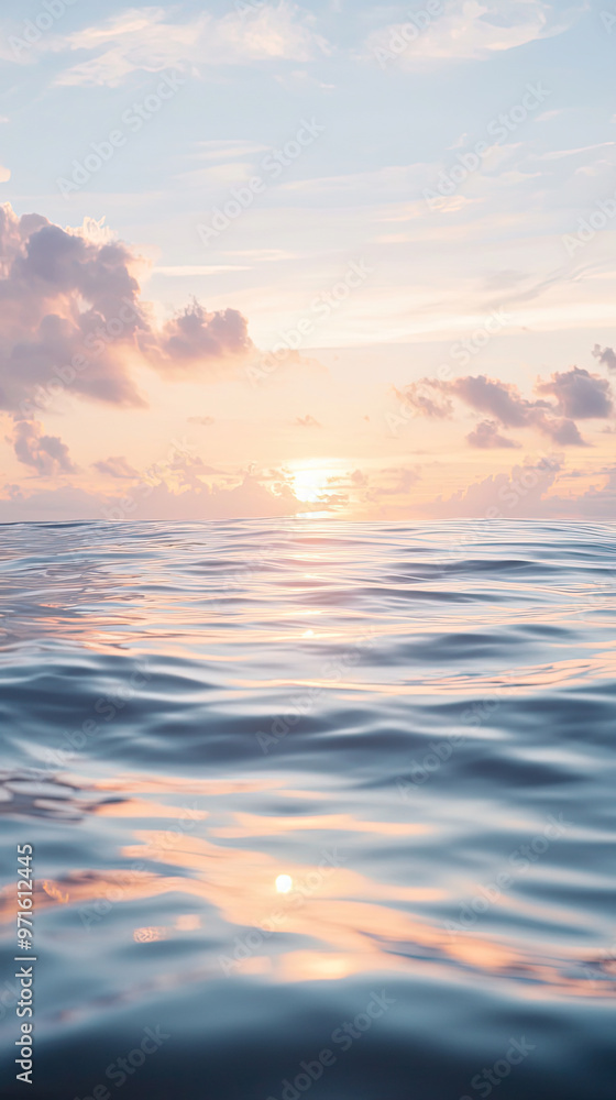 Obraz premium A serene lagoon with gently rippling water reflects soft clouds and sunset