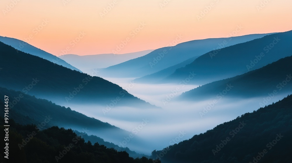 Obraz premium Serene mountain landscape at dawn with misty valleys and soft pastel skies.
