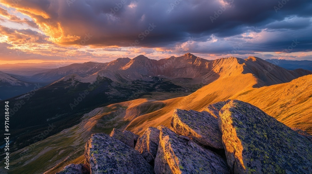 Obraz premium A stunning sunset over rugged mountains, showcasing vibrant colors and dramatic cloud formations.