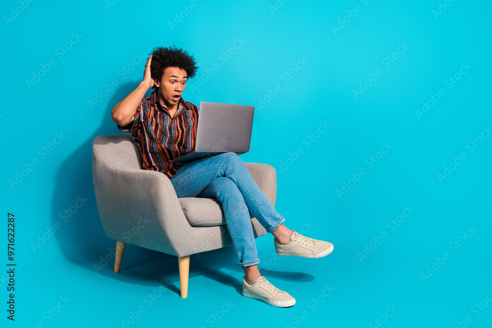 Full size photo of nice young man sit chair use laptop empty space wear shirt isolated on teal color background Full size photo of nice young man sit chair use laptop empty space wear shirt isolated on teal color background