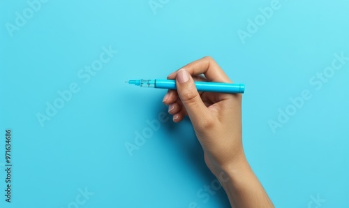 Diabetes. glucose testing. Woman using lancet pen on blue background, top view. Space for text