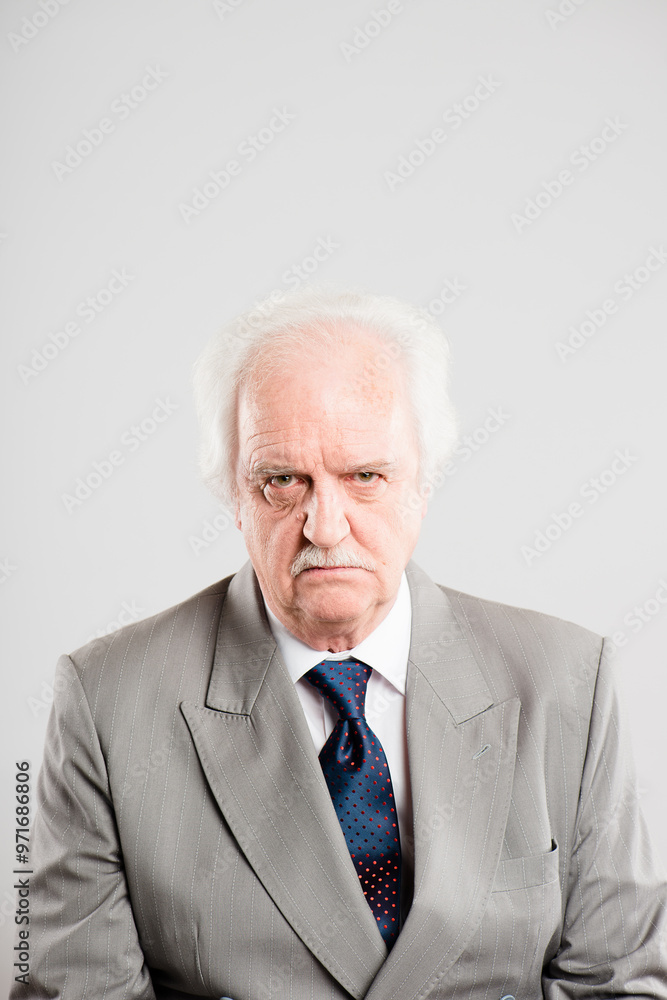 Portrait, senior man and grumpy in studio, unhappy and upset for loss of business, angry and professional. White background, formal and CEO of company, accountant and retirement of mature person Portrait, senior man and grumpy in studio, unhappy and upset for loss of business, angry and professional. White background, formal and CEO of company, accountant and retirement of mature person