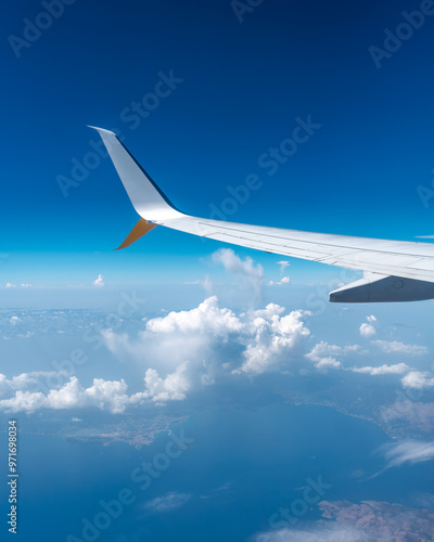 airplane window view with clouds and airplane wing