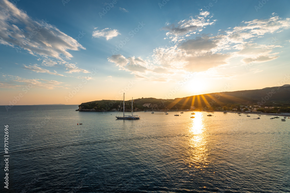 Naklejka premium Sailboat at sunset on the sea. Summer vacation in Greece. Cruise on the Ionian Sea