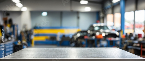 The empty stainless steel table top with blur background of Car Repair Shop. For product display