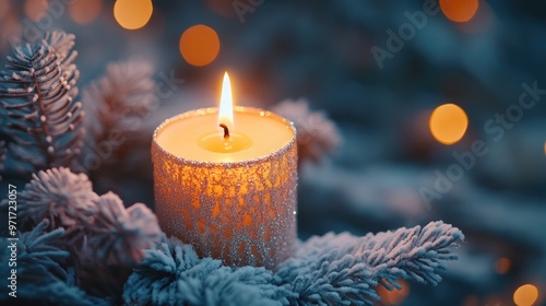 Glittering Candle in Snowy Evergreen Branches with Warm Bokeh Light in Background