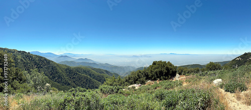 incredible panorama landscape photo of mountains and forest, mist in the distance, beneath a bright blue summer sky - San Bernardino, California