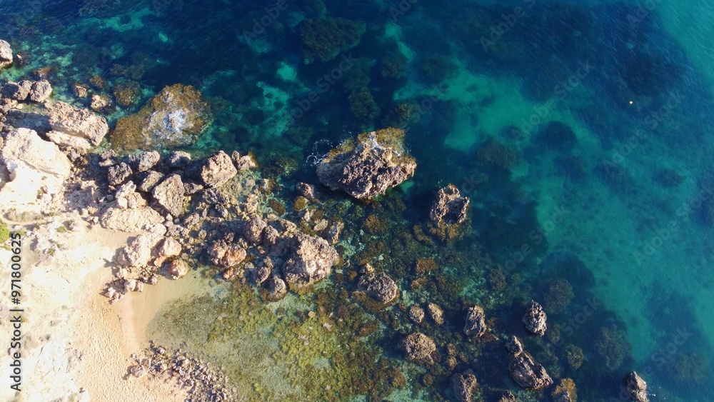 Fototapeta premium Rocky beach and sapphire sea water on the Maltese island, mediterranean sea, Ghajn Tuffieha bay , Malta. High quality photo