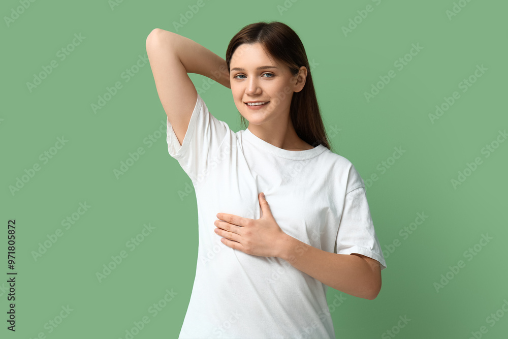Young woman checking her breast on green background Young woman checking her breast on green background