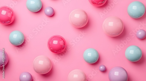 Three dimensional pattern of various spheres flat laid against pink background