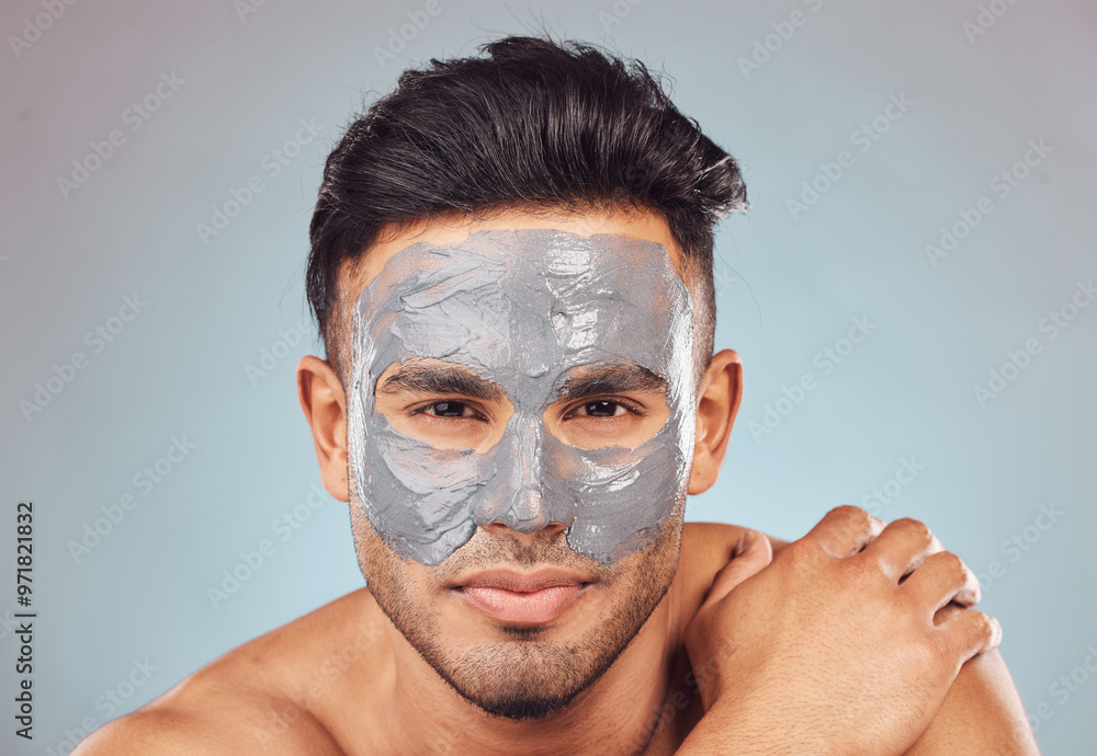 Skincare, portrait and man with mask, charcoal face treatment and product for skin glow on blue background. Cosmetics, dermatology and male person with clay facial detox for morning routine in studio Skincare, portrait and man with mask, charcoal face treatment and product for skin glow on blue background. Cosmetics, dermatology and male person with clay facial detox for morning routine in studio